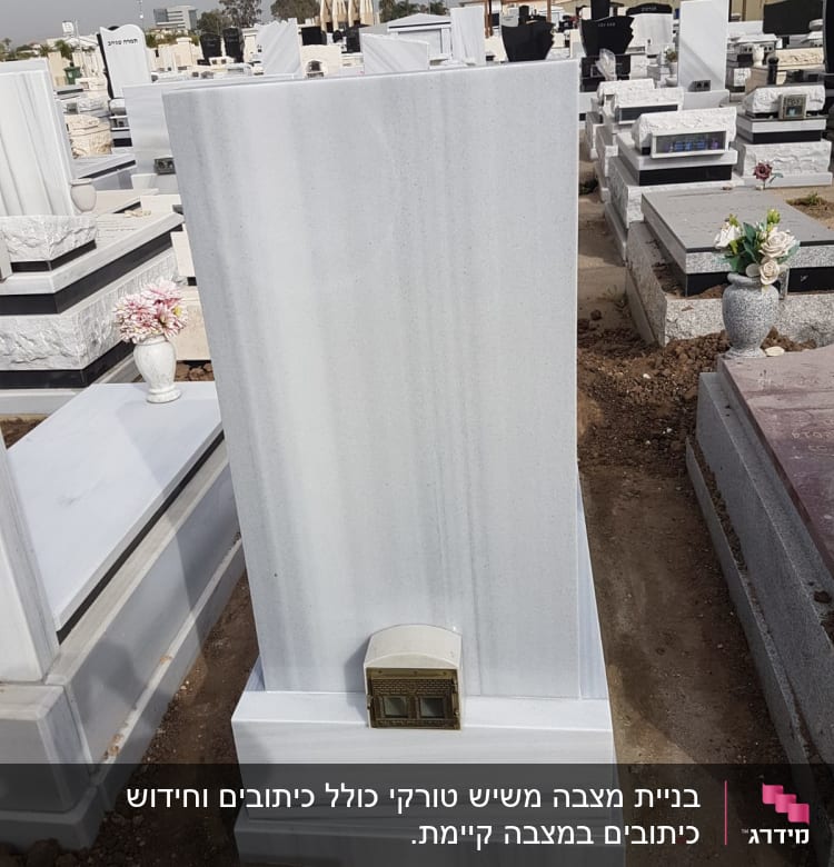 מצבות שיש לבנות עם פרחים באגרטל